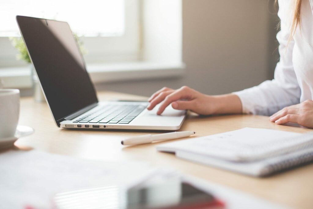 Business woman in an office using her laptop to reasearch about the steps to obtain a business visa in Guatemala. 