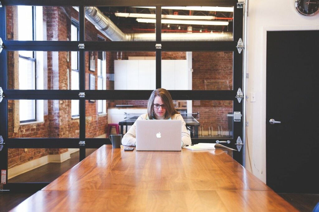 Woman sitting at the end of the table on her laptop